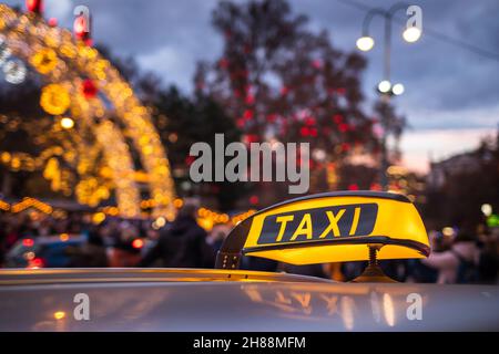 Taxi car in Vienna, Austria near to Rathausplatz Christmas market. Taxi cab at city street. Public transportation in downtown district at night Stock Photo