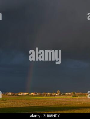 Beautiful rainbow over the Tuscan countryside near Bientina, Pisa, Italy Stock Photo