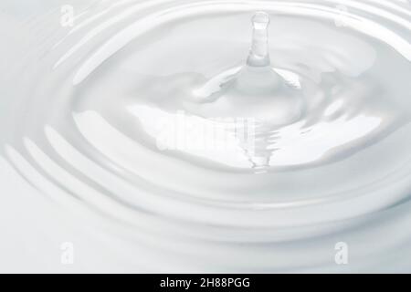 Water drop falling into water making a perfect droplet splash Stock Photo