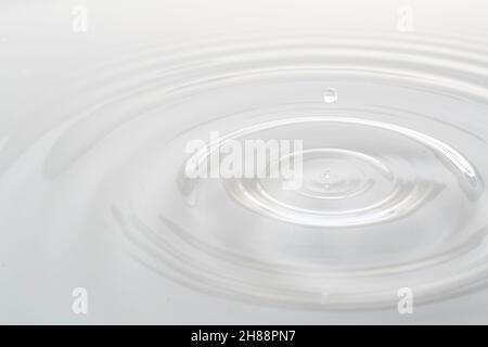Water drop falling into water making a perfect droplet splash Stock Photo