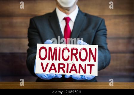 A businessman or scientist wearing PPE and holding a sign with Omicron Variant of the Covid19 virus in text and copy space Stock Photo