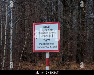 Shooting prohibited sign. Sign in Russian and Tatar: STOP, SHOOTING, NO ENTRY. Stock Photo