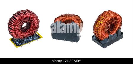 Closeup of various electronic toroidal coils isolated on white. Set of red inductors with copper wire winding in sockets encased by black epoxy resin. Stock Photo