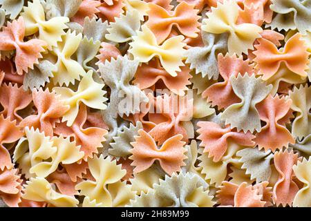Close-up on a stack of colorful uncooked farfalle from Italy. Stock Photo