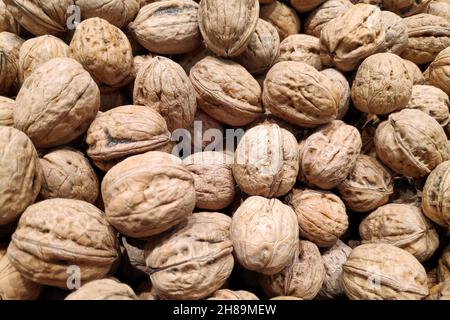 Close-up on a stack of walnuts for sale on a market stall. Stock Photo