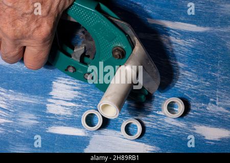 Plumber cuts metal-plastic pipe before soldering. close up Stock Photo