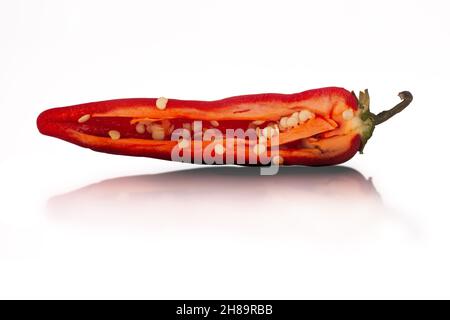 Red hot chilli pepper sliced in half close up isolated on a white background with reflection Stock Photo