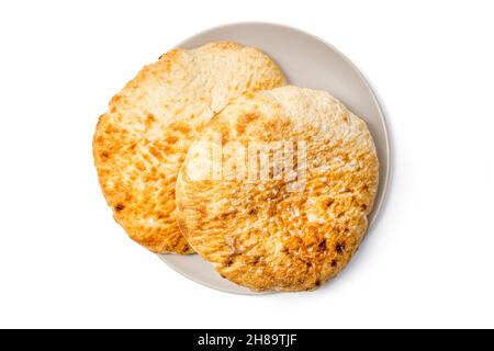 Loafs of flat round wheat bread in a plate isolated on white background with clipping path. Top View Stock Photo