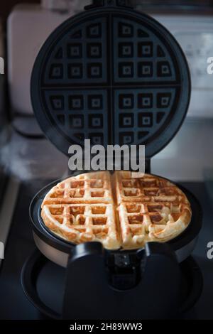 Crispy golden homemade Belgian waffle baked in the waffle iron. Stock Photo