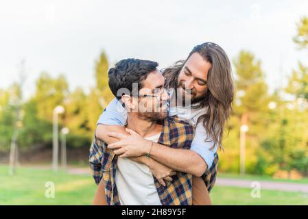 gay male couple having a good time in the park Stock Photo