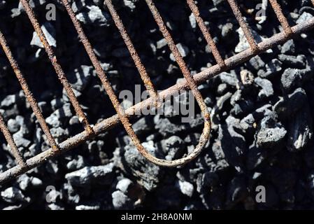 Close up and detail shot of a greasy and rusty grill grate hanging over gray charcoal in a grill Stock Photo