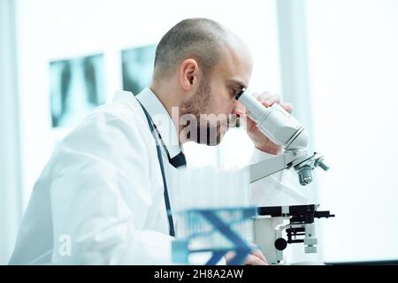close-up. young scientist studying the obtained samples through a microscope .side view. Stock Photo