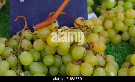 The green grapes on the market have been put up for sale and there is a board in the background where you can write, for example, the price or the typ Stock Photo