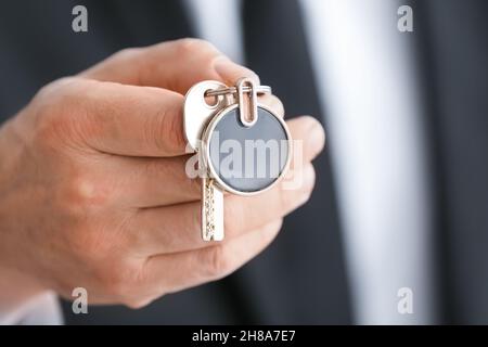 Man holding key on chain, closeup Stock Photo