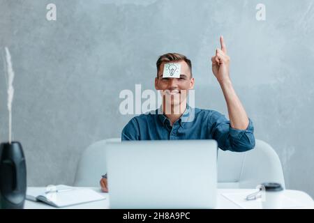 Satisfied man with raised hand thinking about good creative idea. Stock Photo