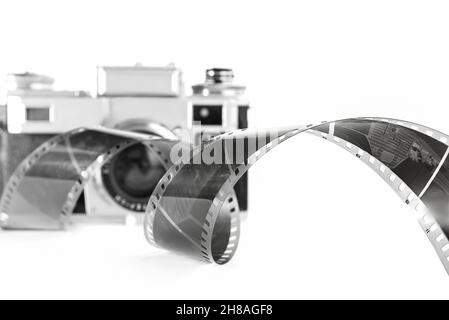 retro camera and camera roll on white background. Black and white photo. Stock Photo