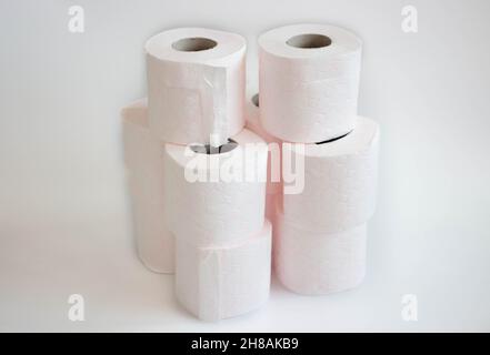 pink patterned stack of white tissue paper rolls , toilet paper rolls over white background Stock Photo
