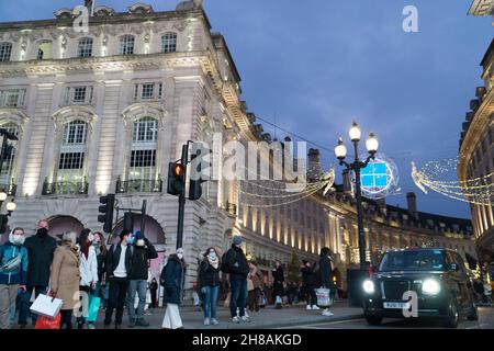 London, UK, 28 November 2021: Christmas shoppers amongst the Christmas lights of Regent Street and Picadilly Circus in the West End of London. Despite concerns about the new variant of coronavirus and the imminent imposition of stricter mask rules in England from Tuesday, the lure of London on a sunny Sunday afternoon was attractive to shoppers hoping to scoop up a bargain from the Black Friday offers still running. Anna Watson/Alamy Live News Stock Photo