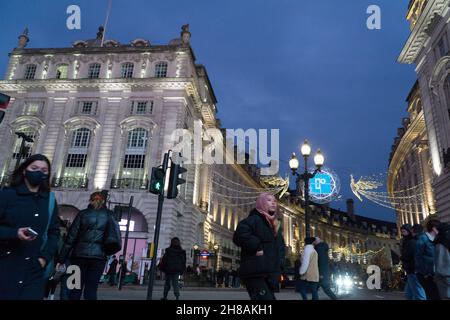 London, UK, 28 November 2021: Christmas shoppers amongst the Christmas lights of Regent Street and Picadilly Circus in the West End of London. Despite concerns about the new variant of coronavirus and the imminent imposition of stricter mask rules in England from Tuesday, the lure of London on a sunny Sunday afternoon was attractive to shoppers hoping to scoop up a bargain from the Black Friday offers still running. Anna Watson/Alamy Live News Stock Photo