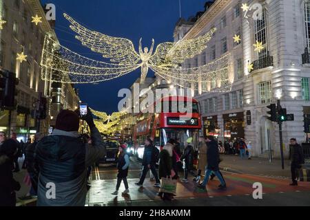 London, UK, 28 November 2021: Christmas shoppers amongst the Christmas lights of Regent Street and Picadilly Circus in the West End of London. Despite concerns about the new variant of coronavirus and the imminent imposition of stricter mask rules in England from Tuesday, the lure of London on a sunny Sunday afternoon was attractive to shoppers hoping to scoop up a bargain from the Black Friday offers still running. Anna Watson/Alamy Live News Stock Photo