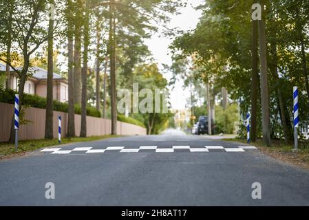 Traffic safety speed bump on asphalt road. Stock Photo