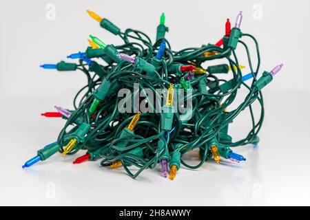 Tangled Christmas string lights isolated on white background. Holiday decoration safety and lighting concept Stock Photo