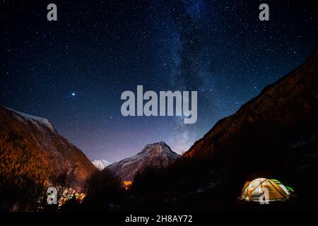 Pitched tent under the milky way during a hike of the tour du mont blanc Stock Photo