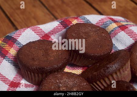 Delicious chocolate cupcakes with baking cloth on wood table Stock Photo