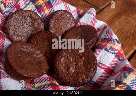 Delicious chocolate cupcakes with baking cloth on wood table Stock Photo
