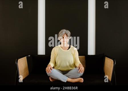 Woman meditating at home Stock Photo