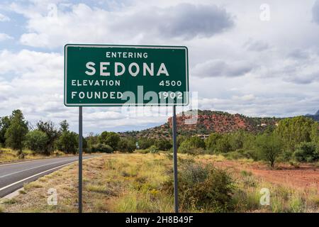 Entering Sedona Elevation 4500 and Founded 1902 sign with road and landscape in soft focus behind Stock Photo