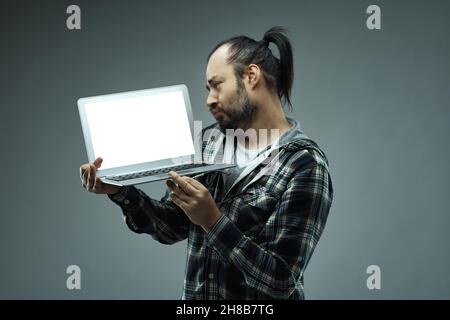 What an adorable and lovely cuteness I see here - a man looks lovingly at the blank screen of his handheld laptop computer with a soft expression and Stock Photo