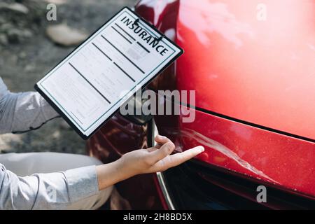 Man agent checking of the damaged car and examines it, Traffic Accident and insurance concept. Stock Photo