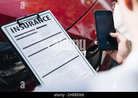 Man agent takes a snapshot of the damaged car and examines it, Traffic Accident and insurance concept Stock Photo