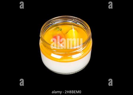 Delicious italian dessert panna cotta with mango sauce and fresh berries isolated on black background. Panna cotta with strawberries isolated Stock Photo