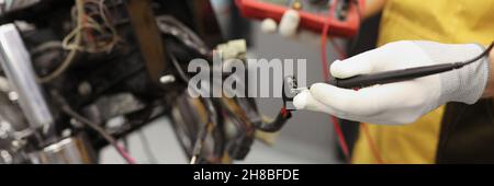 Electronics repair service master using multimeter tester to determine the problem part Stock Photo