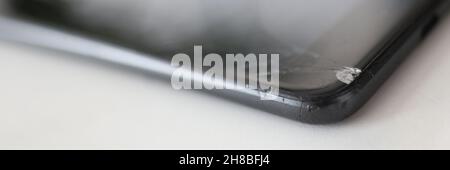 Smartphone with broken front screen is lying on table closeup Stock Photo