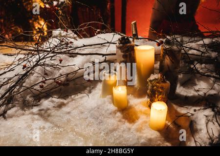Candles in the snow, branches as decoration. Night magic atmosphere, natural decorations for Christmas. Stock Photo