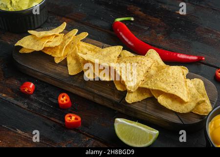 Nachos and guacamole and cheese sauces, on old wooden table Stock Photo