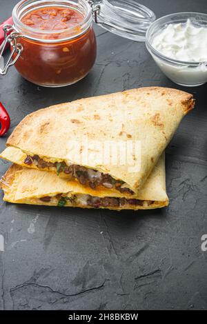 Quesadilla with chicken and sauce, on black background Stock Photo