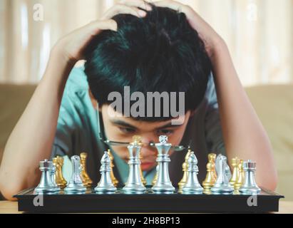 Concentrated serious boy developing chess gambit, strategy ,playing board game to winner clever concentration and thinking child while playing chess. Stock Photo