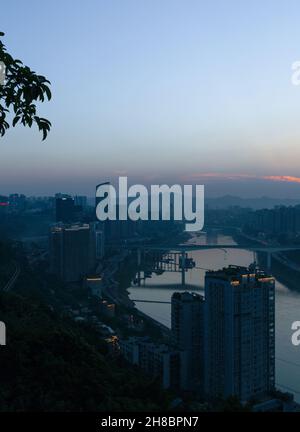 City night view of Chongqing, China after sunset. Skyscrapers on the banks of the Jialing River and the busy city traffic Stock Photo