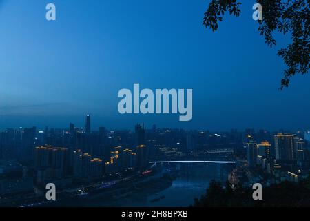 City night view of Chongqing, China after sunset. Skyscrapers on the banks of the Jialing River and the busy city traffic Stock Photo