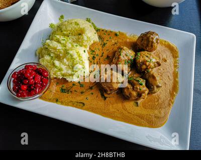 Swedish typical dish consisting of meatballs with sauce, mashed potatoes and ribes. Tasty recipe with Swedish meat balls floating on a thick gravy Stock Photo