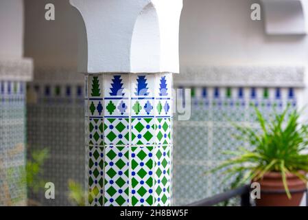 Detail of the interior traditional Moroccan Riad or Riyad with pillar covered by tilles, Morocco Stock Photo
