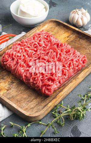 Raw minced meat with spices, vegetables and herbs and meatballs set, on gray stone background Stock Photo
