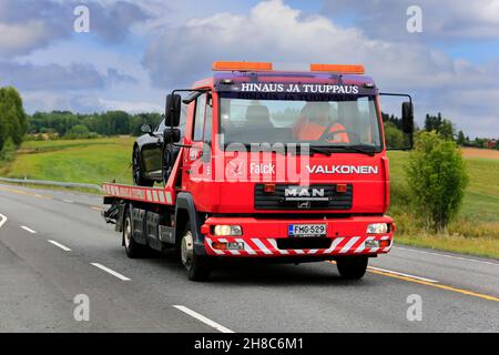 MAN flatbed recovery vehicle of Hinaus ja Tuuppaus Antti Valkonen carrying damaged car along road on an overcast day. Ikaalinen, Finland. Aug 12, 2018 Stock Photo