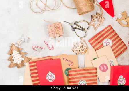 Homemade Original Christmas Advent Calendar of craft paper bags on dark background. Waiting for Christmas with gifts and Sweets surprises. Seasonal ac Stock Photo