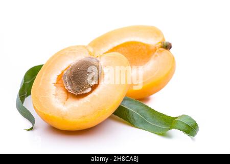 Halves of apricot with seed and leaves isolated on white background Stock Photo