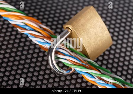 A bundle of colored, twisted wires are passed through a closed lock. The concept of security, welcome. An abstract image. Stock Photo